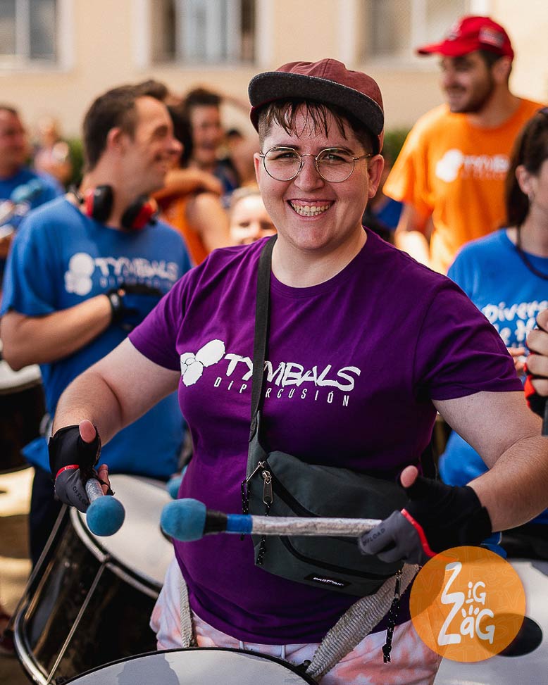 Personas tocando percusión en desfile de calle