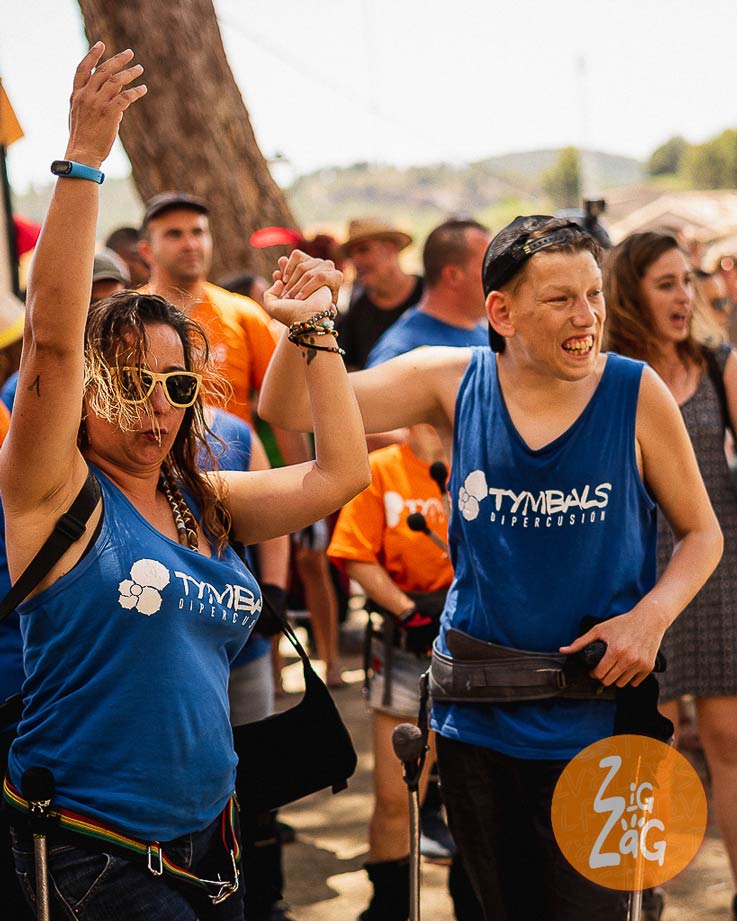 Personas tocando percusión en desfile de calle