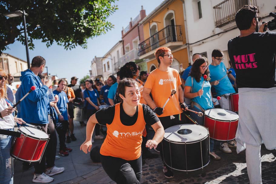 Personas tocando percusión en desfile de calle